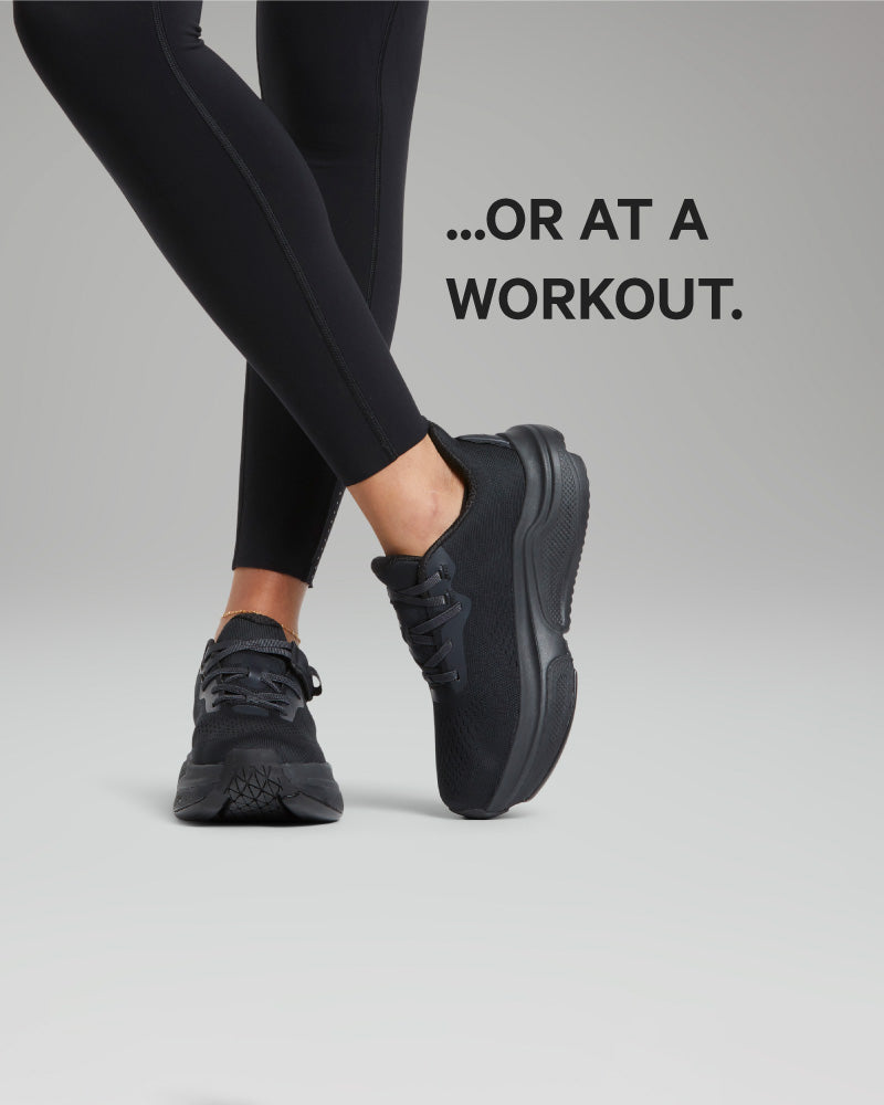 Person wearing black athletic shoes and leggings on a gray background with text '...OR AT A WORKOUT.'