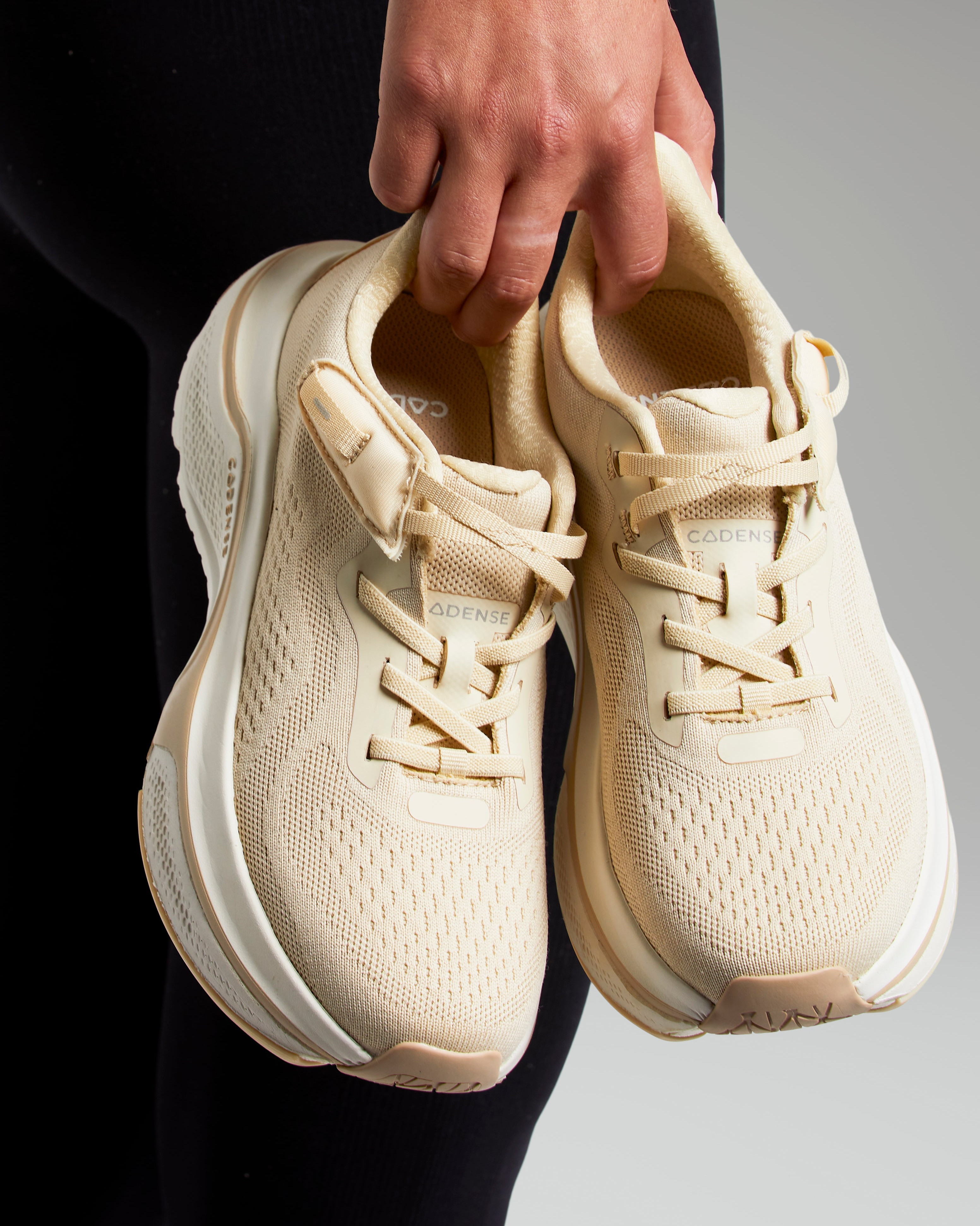 Woman holding a pair of champagne colored shoes