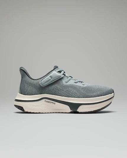 Gray athletic shoe with white sole on a gray background