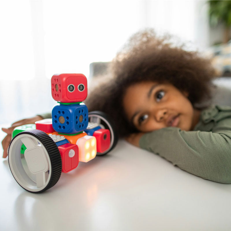 Child playing with a colorful toy robot on a table