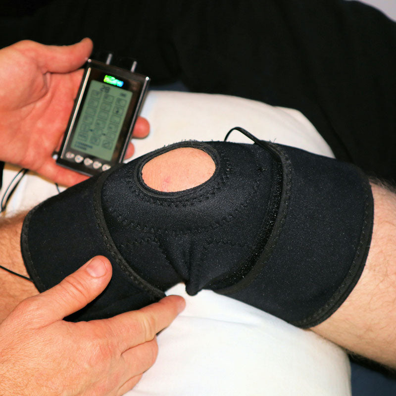 Person using a digital device on a black knee brace