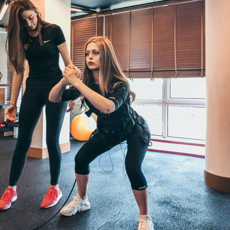 Two women exercising together in a gym setting
