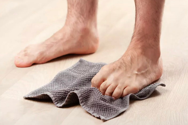 Person's feet on a towel on a light-colored floor