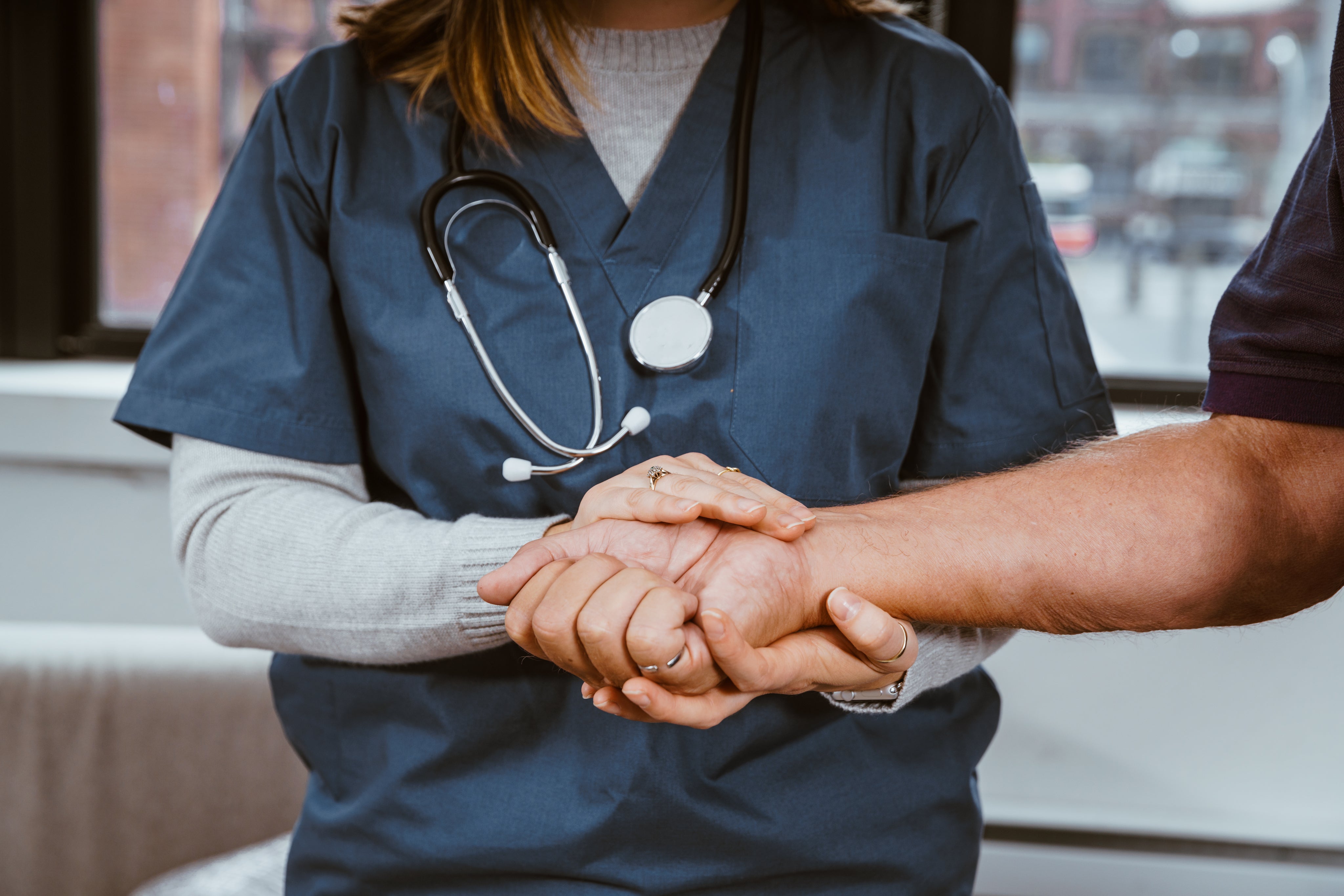 Nurse holding a patient's hand