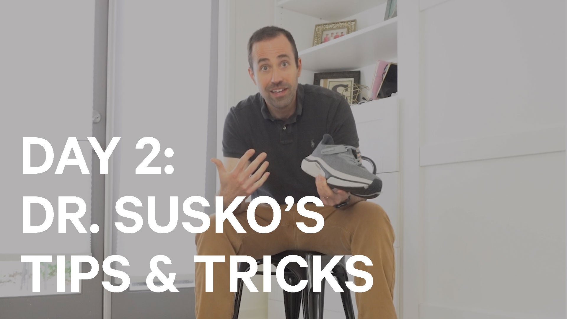 Man holding a shoe with text overlay 'Day 2: Dr. Susko's Tips & Tricks' in a room setting.