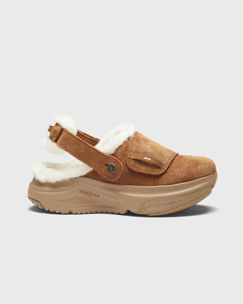 Brown slip-on shoe with white fur lining on a light gray background