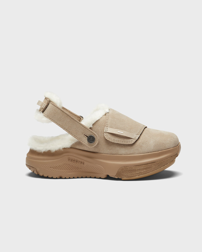 Beige slip-on shoe with white fur lining on a light gray background